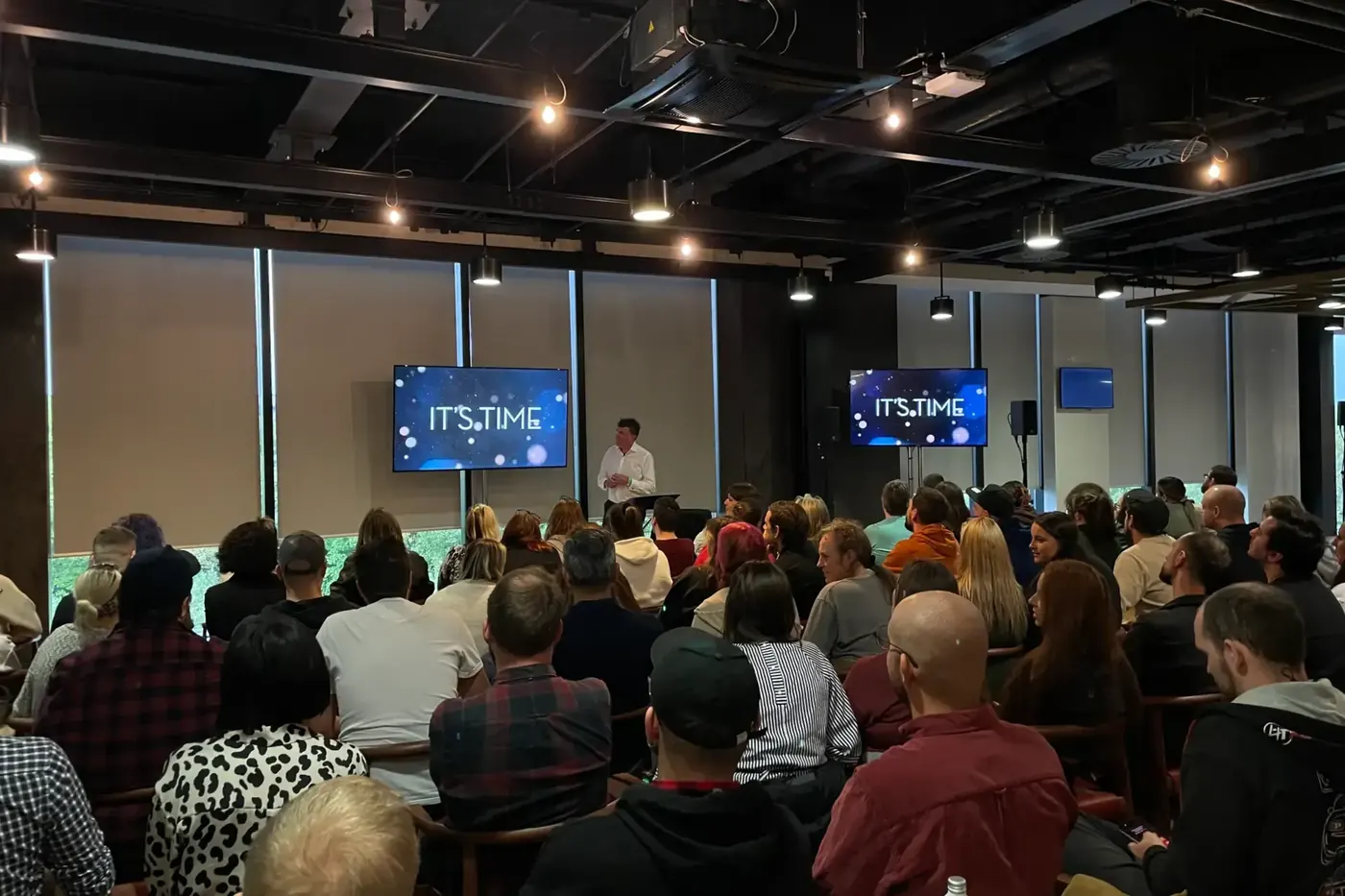Audience watching a presentation on relay screens
